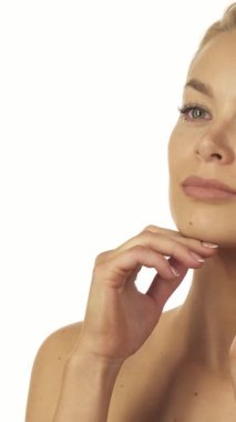 Şık sarışın at kuyruklu çarpıcı genç bir kadın, el değmemiş beyaz bir arka planda hafifçe çenesini ve boynunu okşuyor. Işıl ışıl yeşil gözleri ve ışıl ışıl gülüşü samimiyet ve güven saçıyor, samimi ve davetkar bir portre oluşturuyor.