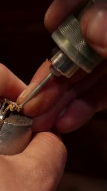 Kendini işine adamış beyaz bir adam usta zanaatkarlığını sergileyerek muhteşem bir mücevher parçasına mükemmel bir mücevher koyar. Sabit elleri, güzel aletlerle süslenmiş, lüks dünyada gerekli olan ustalığı ve hassasiyeti yansıtıyor.