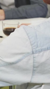 Bu büyüleyici yakın çekim yakışıklı, sakallı bir iş adamının parlak, modern bir ofiste renkli diyagramları incelerken pozitiflikle ışıldamasını içeriyor. Çekici gülümsemesi ve enerjik enerjisi işbirliğinin ve yaratıcılığın davetkar atmosferini yaratıyor.