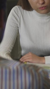 Kesilmiş bir dikiz görüntüsü, bir dizüstü bilgisayardaki canlı verileri analiz eden, iş arkadaşlarıyla odaklanmış, şık beyaz bir kazak giyen bir kadını ortaya çıkarıyor. Modern yönetim kurulu enerji ile uğulduyor, profesyonelliğin bir karışımı ve