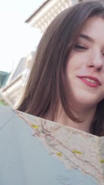 Canlı bir sahne, biri kıvırcık saçlı, diğeri düz saçlı iki genç kadını resmediyor, resmedilmeye değer bir şehir planına karşı ayrıntılı bir haritayı hevesle inceliyorlar. Parlak ifadeleri heyecanı ve merakı yansıtıyor.