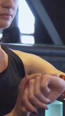 Bu çarpıcı yakın planda, uzun sarı saçlı, at kuyruklu odaklanmış genç bir kız enerjik spor kol saatini ayarlıyor, heyecan verici bir antrenmana hazırlanıyor. Görüntü onun kararlılığını ve gücünü yansıtıyor.