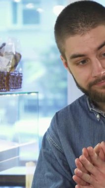 Neşeli genç bir erkek tezgahtar, şık bir sakalı olan, bir bayan müşteriyle tutkulu bir şekilde yakınlaşan, parlak, davetkar bir fırında ağız sulandıran hamur işleri yapan. Sıcak atmosfer, fırının tatlı aromasıyla dolu.