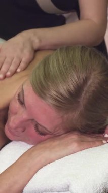 Sakin ve varlıklı bir kaplıcada, genç sarışın bir kadın yetenekli bir terapistin canlandırıcı sırt masajından zevk alır. Mumların yumuşak parıltısı ve yumuşak müzik mekanı kaplıyor. Huzur ve rahatlama vahası yaratıyor.