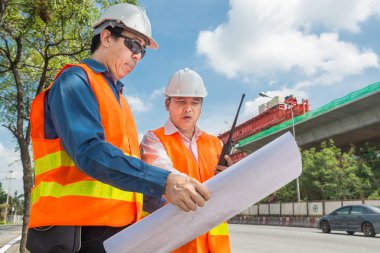 Mühendis ve mimarı ya da Foreman beyaz kask giymek ve ağır sanayi kavram olarak inşaat alanında ve denetiminin karayolu proje geliştirme Emanet bez toplantı kızdırma.