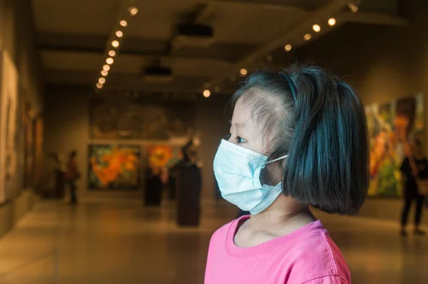 Girl Wearing Medical Mask while traveling in Public Art Museum or Gallery Hall as New Normal Lifestyle Traveling in Situation of Covid-19 or 2019 Corona Virus Pandemic Disease.