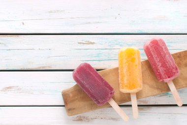 Ahşap arka plan üzerinde çeşitli aromalı Ice popsicles