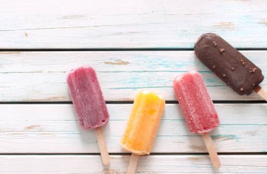 Ahşap arka plan üzerinde çeşitli aromalı Ice popsicles
