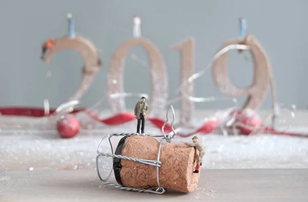 微型人们爬上一个香槟酒瓶软木塞与2019年木块的背景 — 图库照片