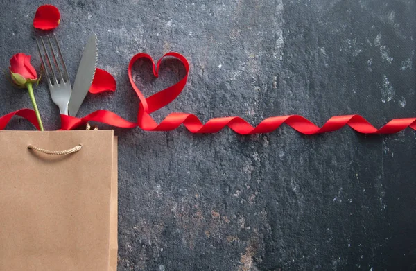 赤いリボンの心のギフト袋の中にナイフとフォーク — ストック写真