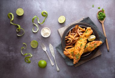 Patates kızartması, maydanoz ve limonlu kızarmış balık.