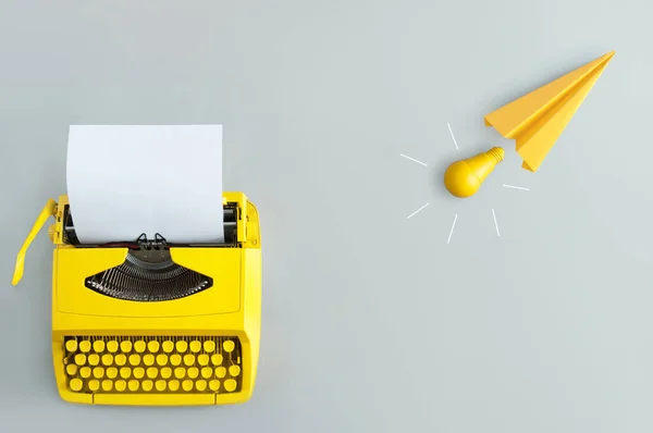 Retro Schreibmaschine Mit Gelbem Papierflugzeug Und Glühbirnen Inspiration Und Innovation — Stockfoto