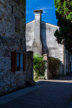 Duvarında baca olan eski bir ev. Bir İtalyan şehrinde sokak