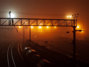Railway night, fog and light in the distance