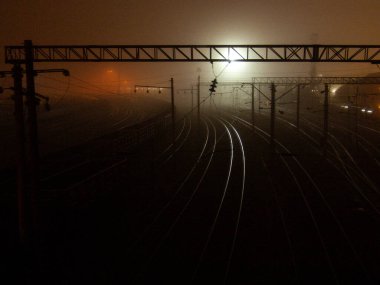Railway night, fog and light in the distance