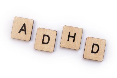 The abbreviation ADHD - Attention Deficit Hyperactivity Disorder - spelt with wooden letter tiles. clipart