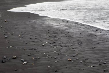İzlanda'nın Güney sahil üzerinde Vik balıkçı köyü yakınındaki Reynisfjara plajda, siyah kum bir görünümü.