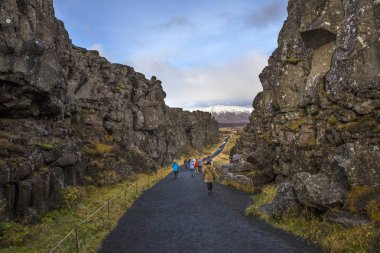 Thingvellir, İzlanda - 10th Ekim 2018: Kuzey Amerika ve Avrasya tektonik plaka içinde tarihi Thingvellir Milli Park alanında İzlanda arasındaki yürüyüş ziyaretçi. 