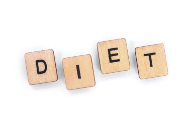 Ahşap mektup taşlarla beyaz bir arka plan üzerinde spelt kelime Diyet-.