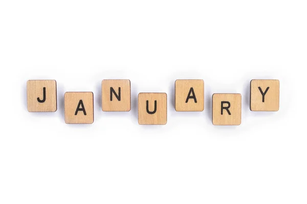 JANUARY, spelt with wooden letter tiles over a plain white background.