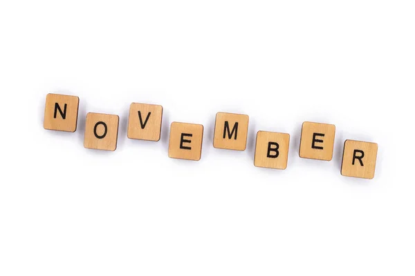 11月 拼写与木制字母瓦片在一个纯净的白色背景 — 图库照片