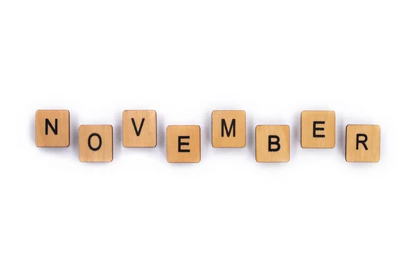 NOVEMBER, spelt with wooden letter tiles over a plain white background.