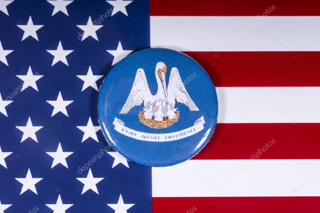 London, UK - November 15th 2018: A badge portraying the emblem of the State of Louisiana, pictured over the United States of America flag.