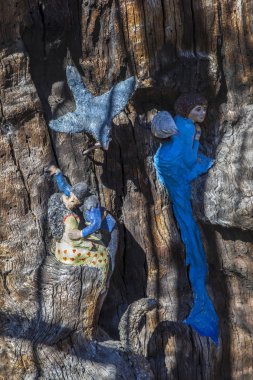 London, UK - September 27th 2018: A close-up of the sculptured carvings of Elves, Fairies and Animals on the historic Elfin Oak in Kensington Gardens, London. clipart