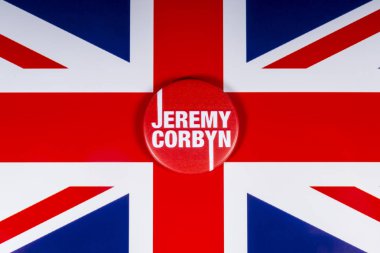 London, UK - November 20th 2018: A Jeremy Corbyn pin badge - leader of the British Labour Party, pictured over the flag of the United Kingdom. clipart