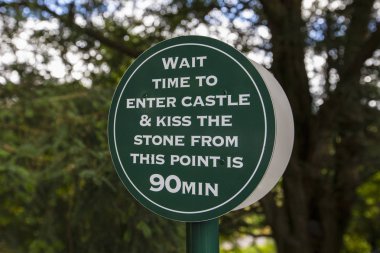 Blarney, İrlanda - 16 Ağustos 2018: ziyaretçi Blarney Stone tarihi Blarney kalede öpmek için bekleme süresi 90 dakika olduğunu bildiren bir işaret. 