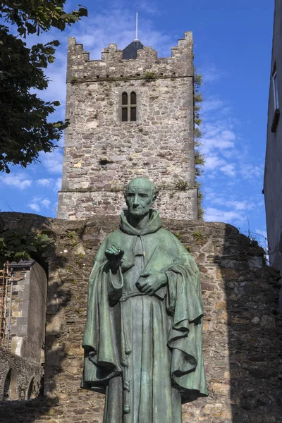 A statue of Irish Franciscan friar Luke Wadding with the French Church friary in the background, in the historic city of Waterford in Republic of Ireland.