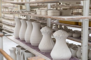 Belleek, Kuzey İrlanda - 22nd Ağustos 2018: Sırsız ve unfired çanak çömlek parçaları hazır kadar Belleek, Belleek seramik fabrikasında üretim sonraki aşaması için Kuzey İrlanda dizilmiş. 