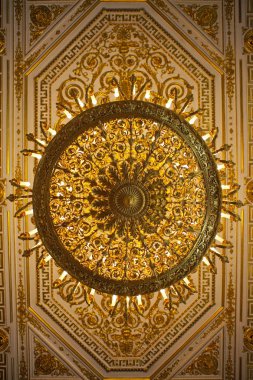 St. Petersburg, Russia - August 16th 2011: Looking up at a stunning golden chandelier and ornate ceiling inside the Hermitage Museum in the city of St. Petersburg, Russia. clipart