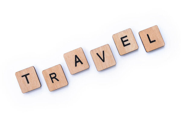 The word TRAVEL, spelt with wooden letter tiles, over a white background.