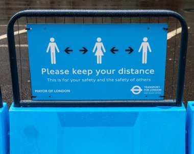 Londra, İngiltere - 17 Haziran 2020: Londra şehir merkezindeki bir tabela, insanların sosyal uzaklık yönergelerine uyduğunu ve diğerlerinden 2 metre uzakta durduğunu hatırlatıyor.