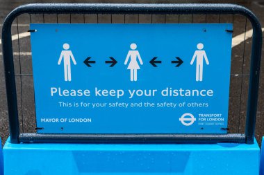 Londra, İngiltere - 17 Haziran 2020: Londra şehir merkezindeki bir tabela, insanların sosyal uzaklık yönergelerine uyduğunu ve diğerlerinden 2 metre uzakta durduğunu hatırlatıyor.