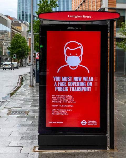 2020 코로나 바이러스가 유행하는 런던에서 정류장 통근자들에게 교통을 얼굴을 가려야 — 스톡 사진