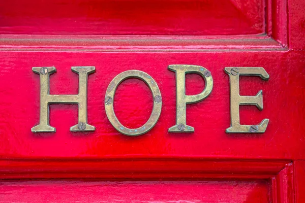 Hope这个词拼写在一扇红门上 — 图库照片