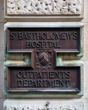 London, UK - August 18th 2020: A plaque on the exterior of St. Bartholomews Hospital Outpatients Department in London, UK. clipart