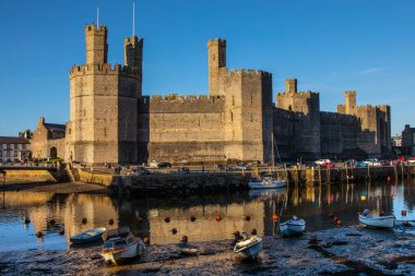 Caernarfon, Galler - 31 Ağustos 2020: Kuzey Galler 'deki Caernarfon kasabasındaki güzel Caernarfon Kalesi manzarası.