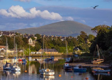 Caernarfon, Galler - 31 Ağustos 2020: Güzel Caernarfon Limanı 'ndan Kuzey Galler' deki Snowdonia Ulusal Parkı 'na bakan bir manzara.