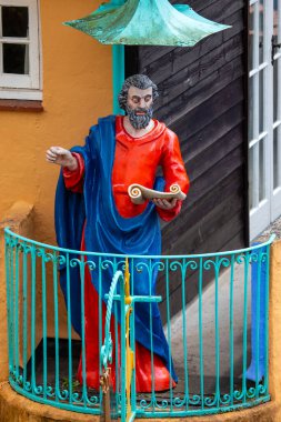 Portmeirion, Wales - Sept 1st 2020:  A statue of Saint Peter located on the exterior of the Toll House in the village of Portmeirion in North Wales, UK. clipart