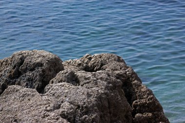 Kaya bir arka plan mavi su üzerine kapatın. Büyük uzay yazmak için. Odak bir uçurum, bulanık deniz ayarla.