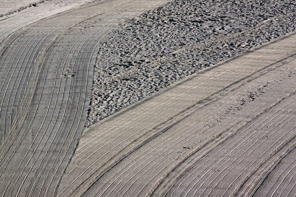 Limpiado por un tractor y gente pisoteada arena en el Mediterráneo —  Fotos de Stock