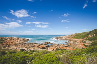Wide angle landscape image of rock formations and the indian ocean along the Garden Route coast of South Africa clipart