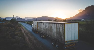 Gün batımına doğru giden bir kargo kamyonunun hava görüntüsü.