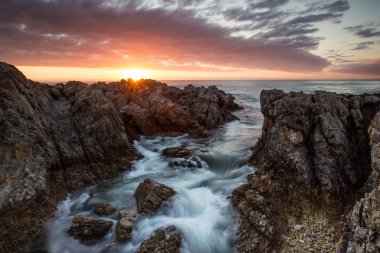 Kumtaşı kayalıklarla Gansbaai Overberg Güney Afrika'nın içinde De Kelders kıyı şeridi boyunca üzerinde güzel gün batımı
