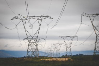 Close up image of overhead power lines sending electricity country wide clipart