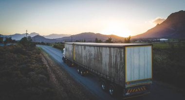 Gün batımına doğru giden bir kargo kamyonunun hava görüntüsü.