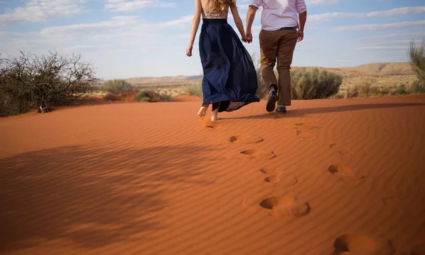 一对漂亮的情侣手拉手走在南非卡拉哈里地区的红沙丘上 — 图库照片